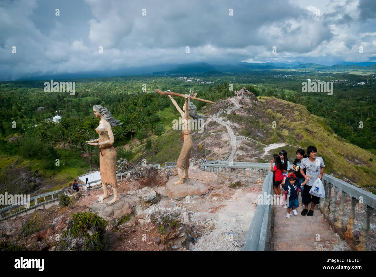 Visitors stepping up concrete stairs leading to the main attractions at Bukit Kasih, a popular destination in North Sulawesi, Indonesia. Stock Photo