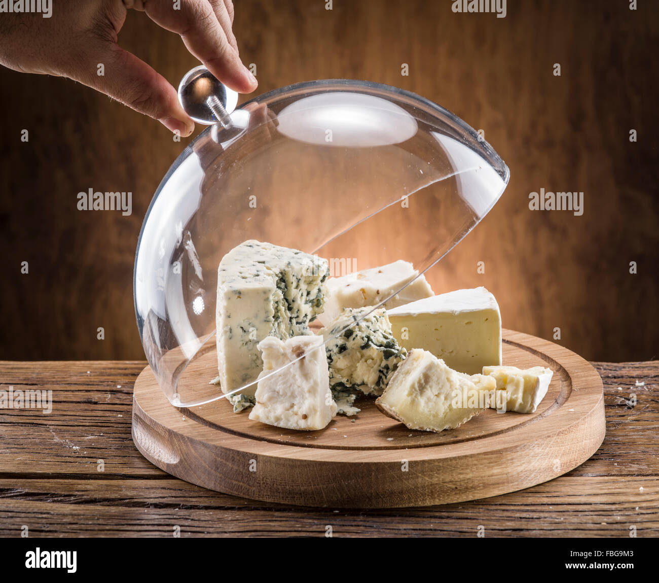 Variety of cheeses on a wooden board. Stock Photo