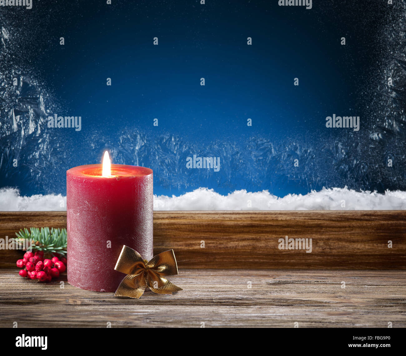 Winter window with burning candle. In the night. Stock Photo