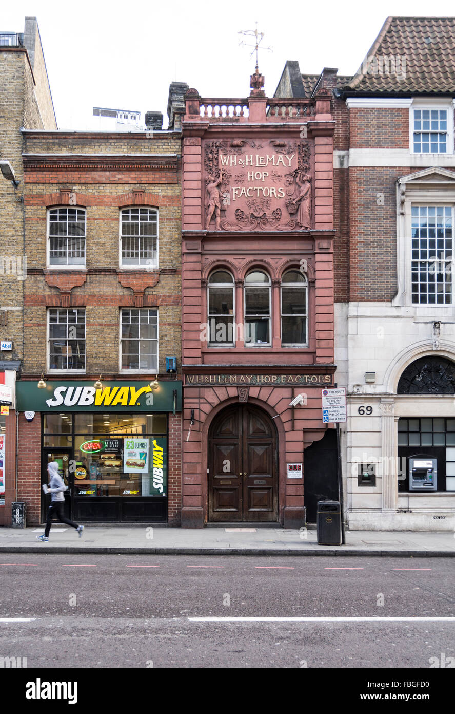 An early morning jogger runs past a Subway sandwich shop in Borough High Street, London, Southwark Stock Photo