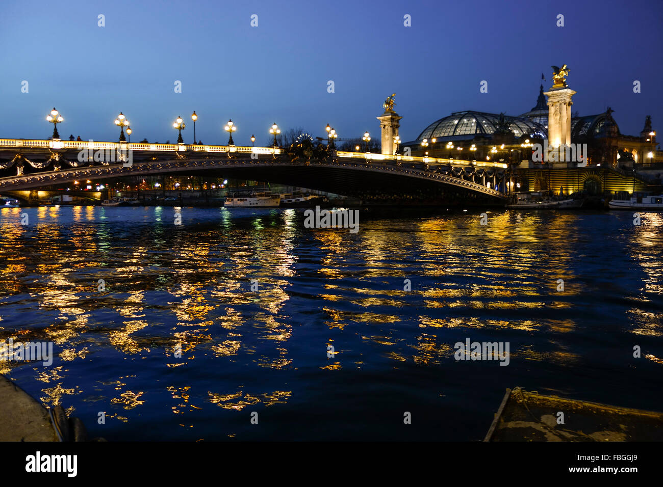 The Pont Alexandre III, arch bridge in Paris at night, Grand Palais behind, France. Stock Photo