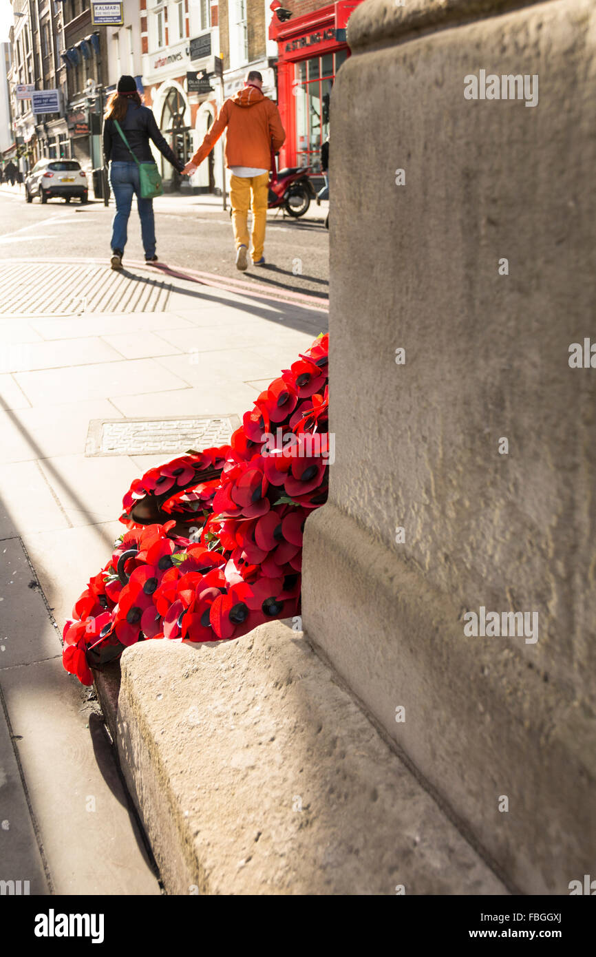 A wreath of red poppies laying in a London street commemorates the sacrifice of men and women in the first  & second world wars. Stock Photo