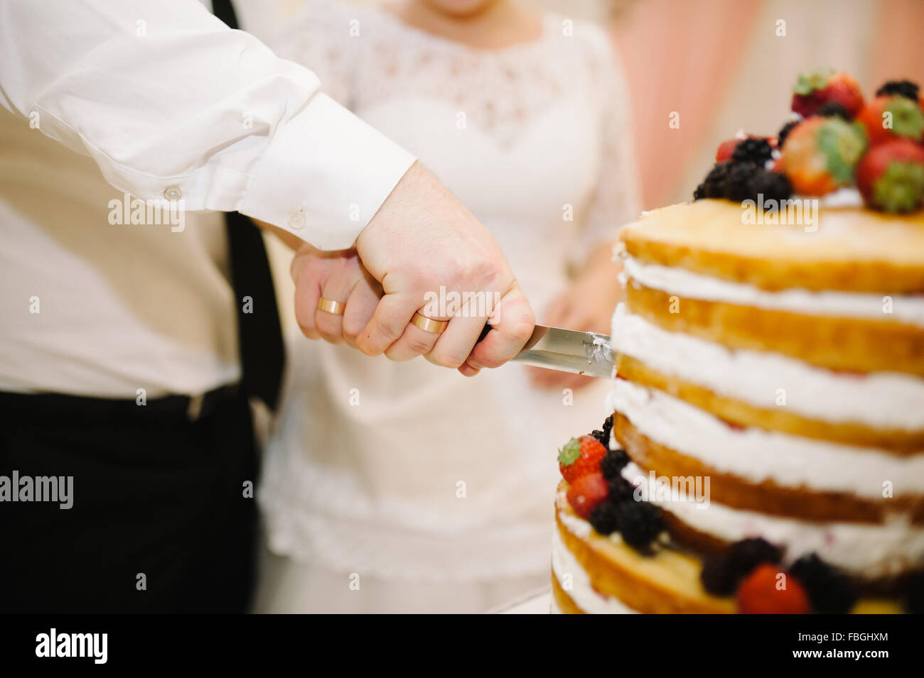 Bride and groom cut their wedding cake together Stock Photo