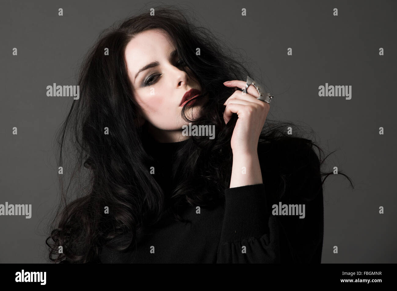 Beautiful female fashion model portrait with dark hair, pale skin, gothic looking Stock Photo