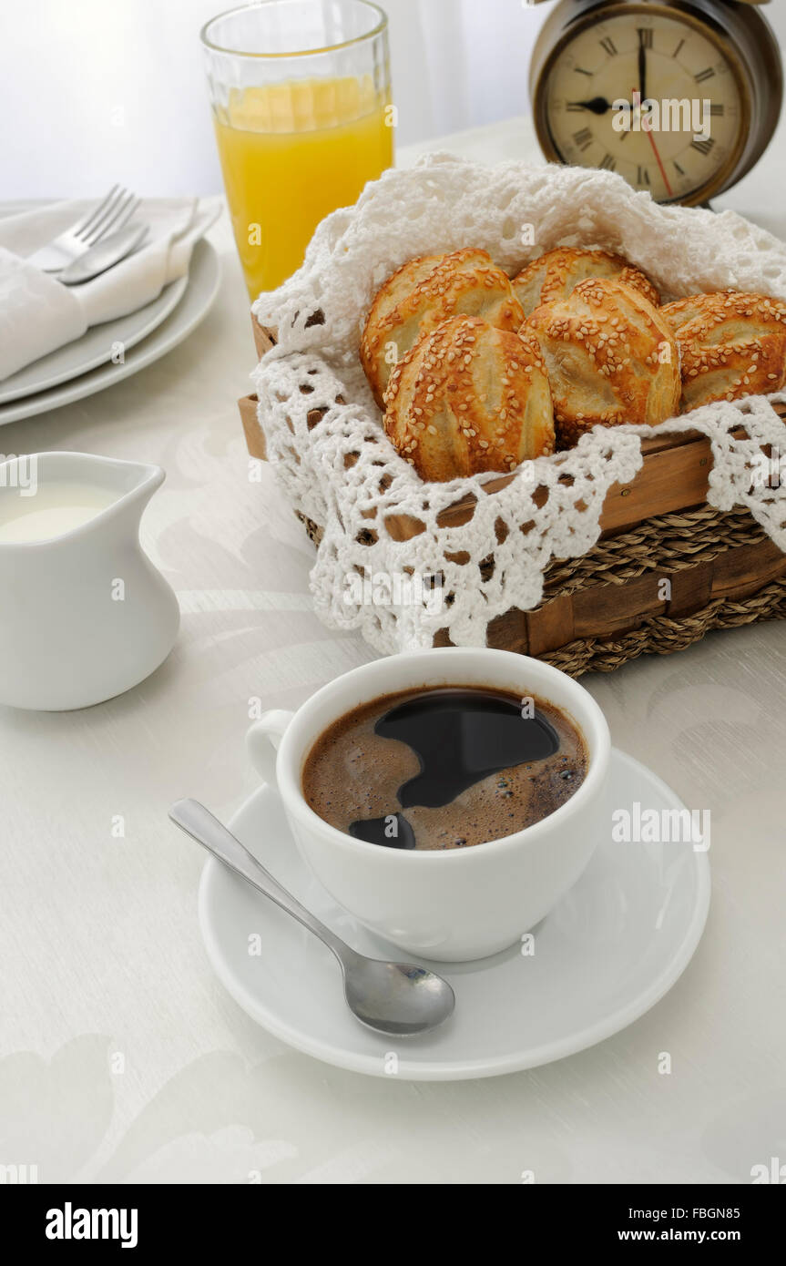Morning cup of coffee with freshly baked rolls with sesame seeds, juice and milk Stock Photo