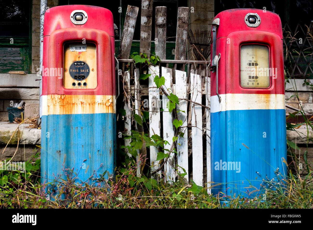 Old gas pumps sits resting in front of a closed general store and gas