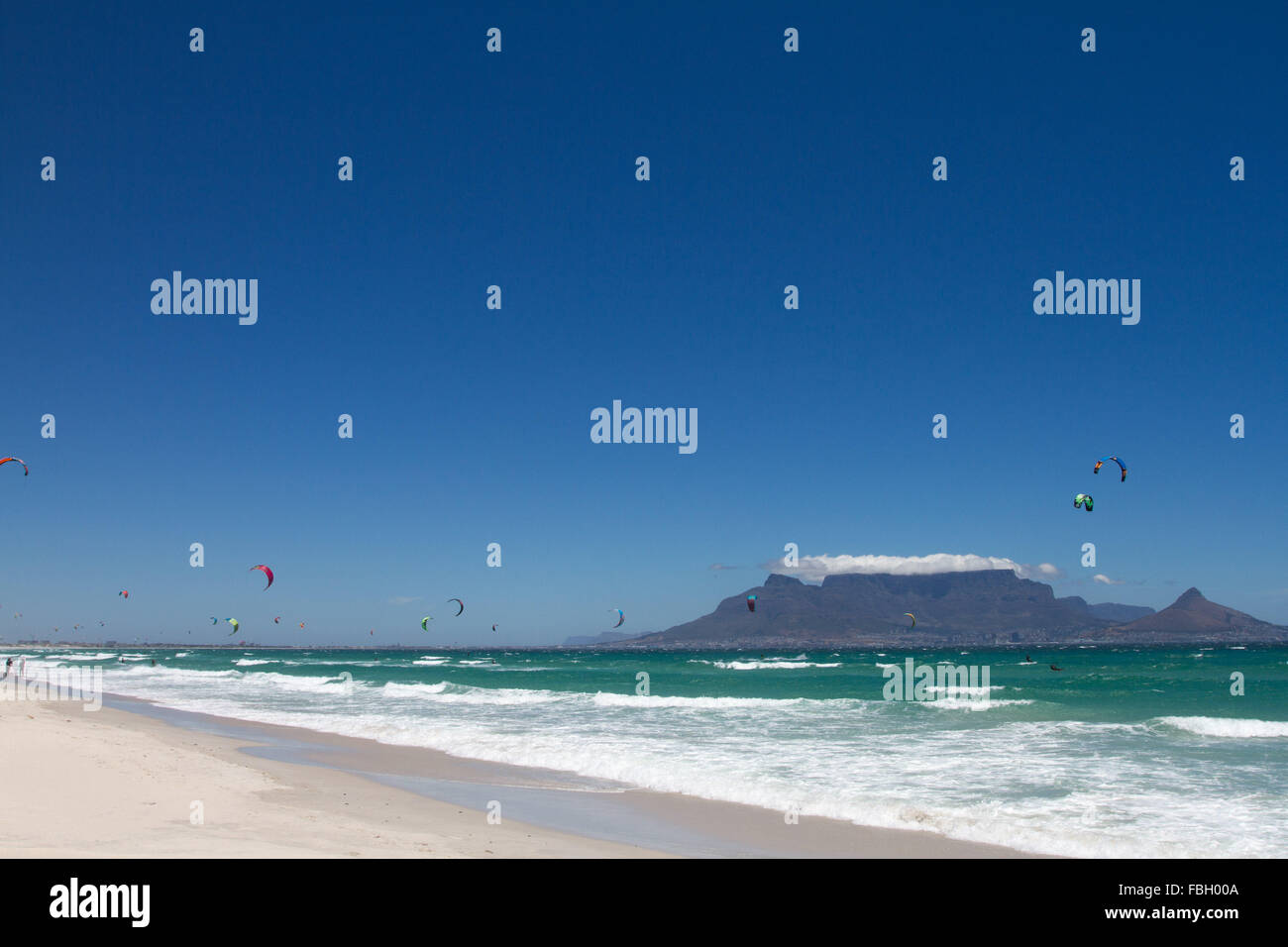 Kitesurfing at Big Bay, Cape Town, with Table Mountain in the background. Stock Photo