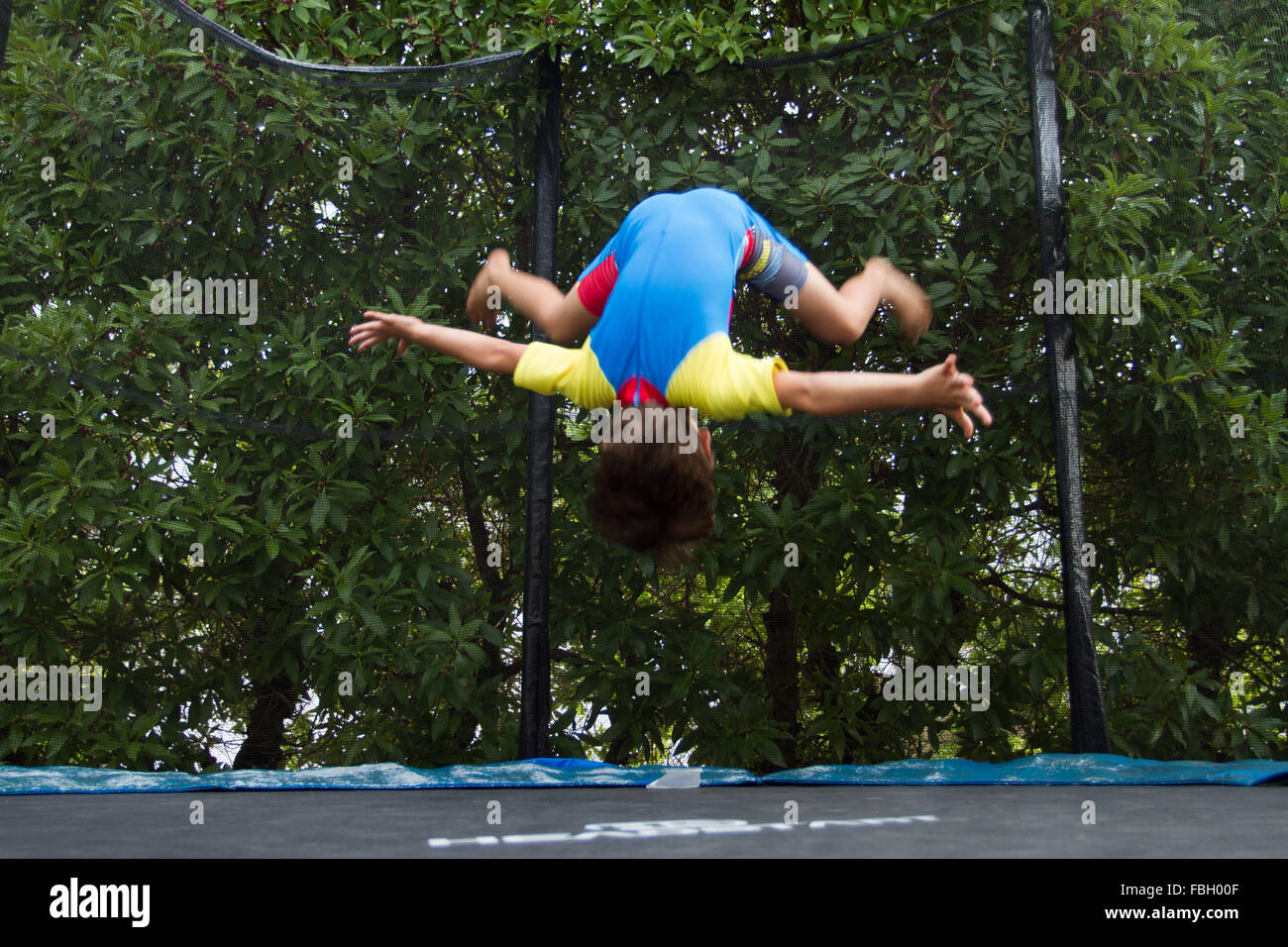 Young boy doing somersault on a trampoline. Stock Photo