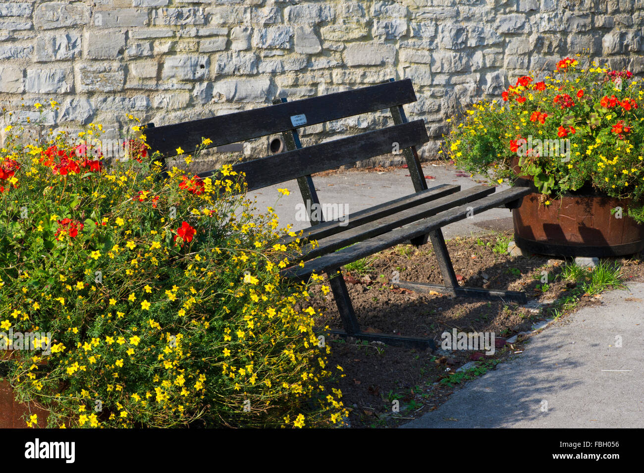 Park Bench And Flower Pots In An English Village Stock Photo