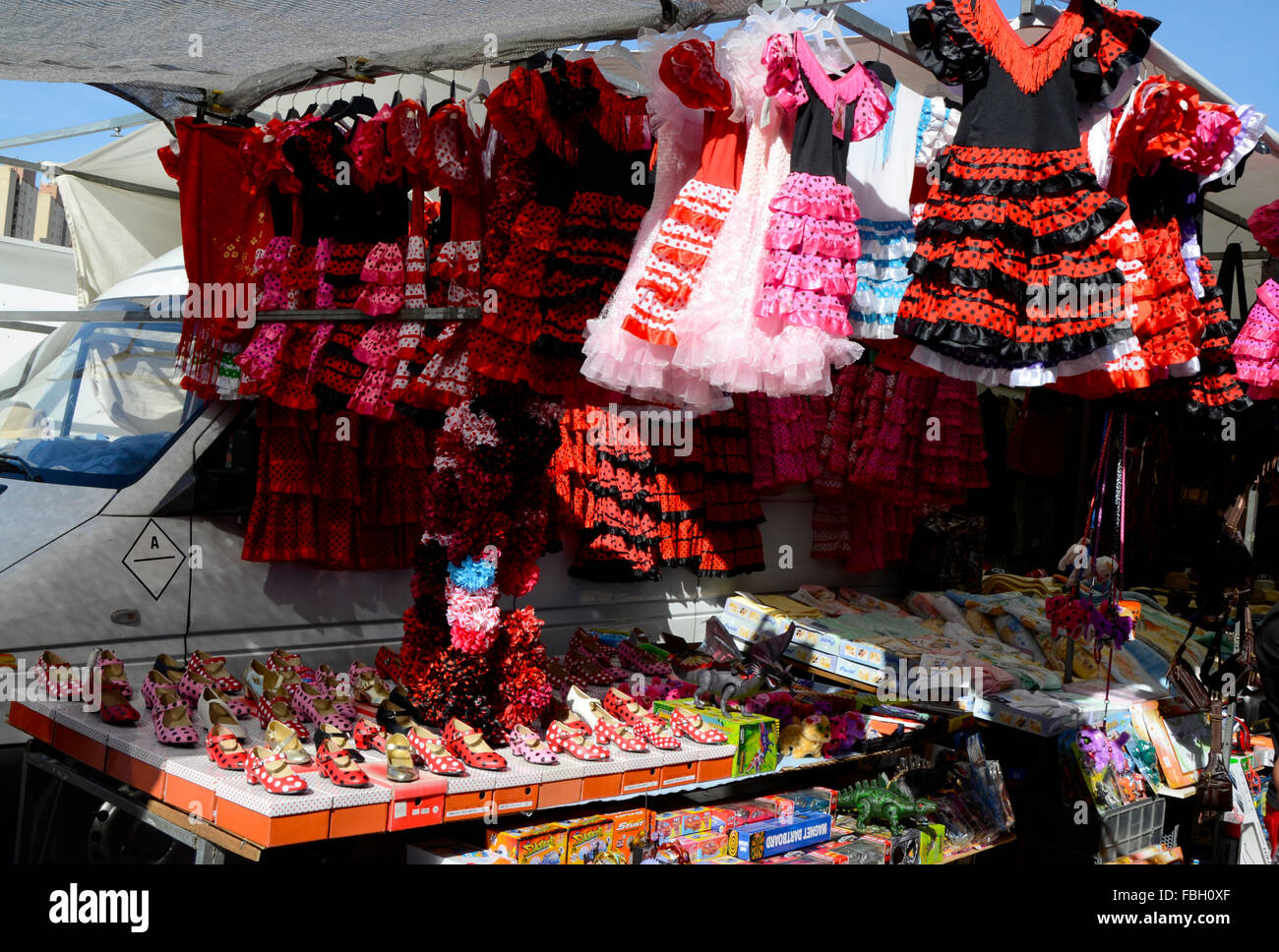 Stand with flamenco dresses for tourists children on a weekly market in Benidorm, Alicante, Spain Stock Photo