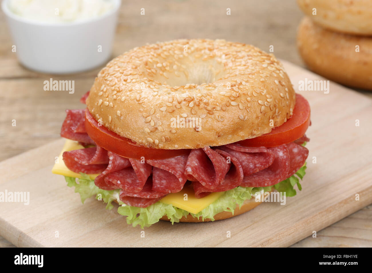 Bagel sandwich for breakfast with salami ham, cream cheese, tomatoes