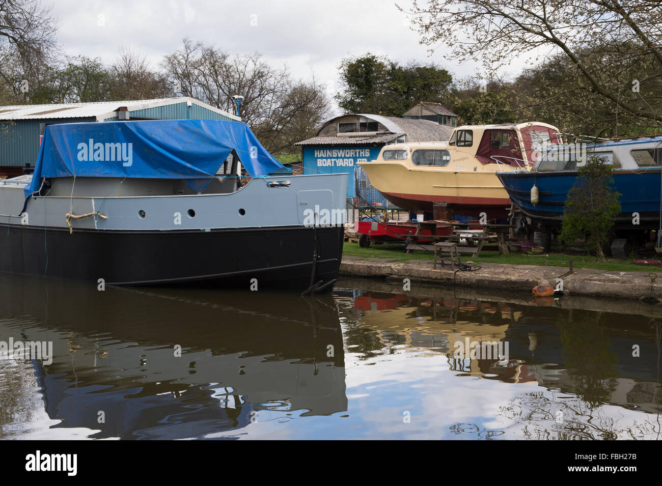 Boats at Hainsworths Boatyard on the Leeds and Liverpool Canal, Bingley, where canal boats are repaired and moored - West Yorkshire, England, GB, UK. Stock Photo