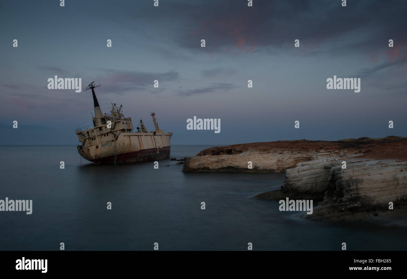 Abandoned Ship on the rocky coast  with beautiful blue and orange morning colors at Paphos area in Cyprus Stock Photo