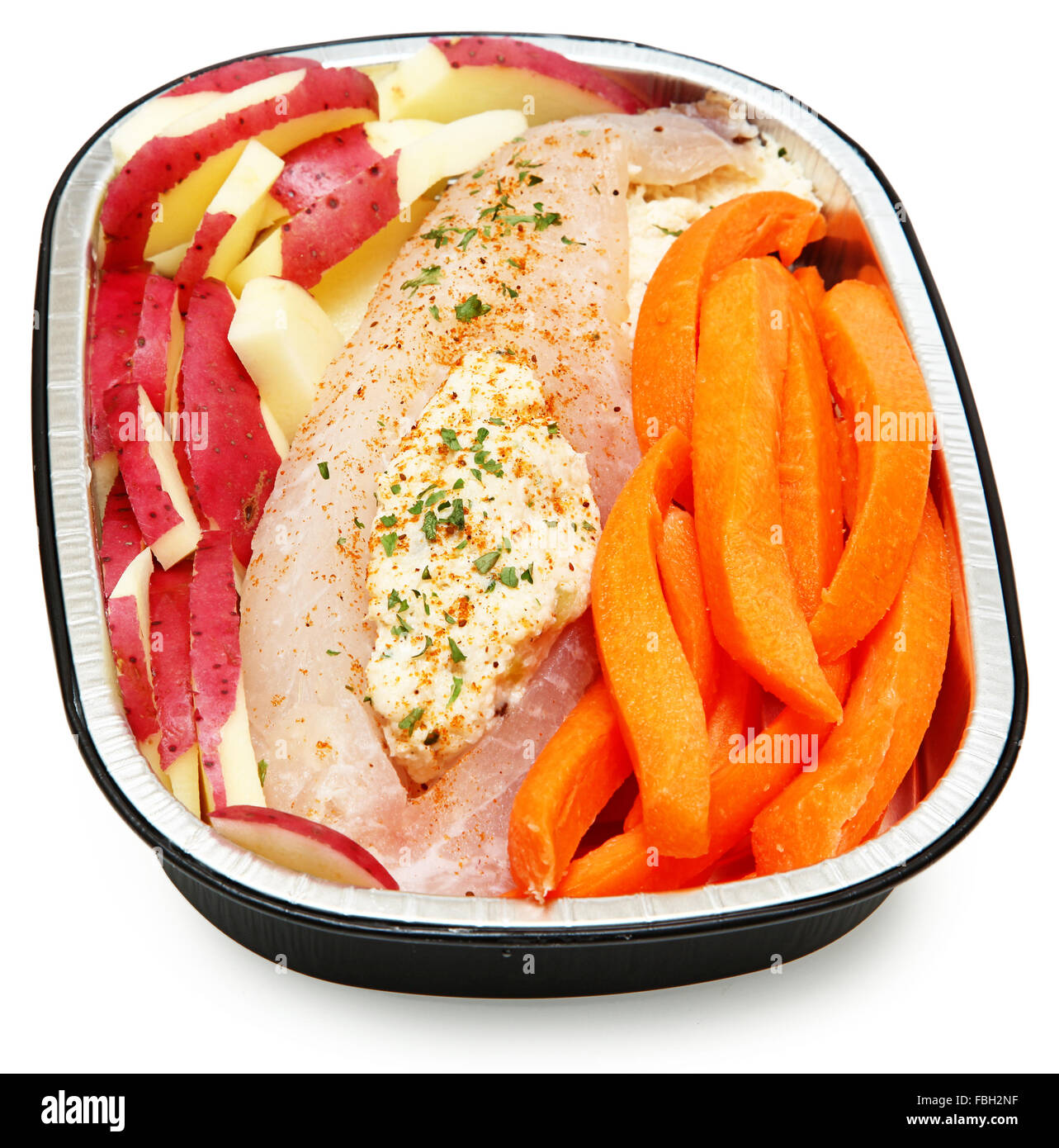 Raw Prepared Crab Stuffed Tilapia with carrots and potatoes Ready for the Oven. Isolated on