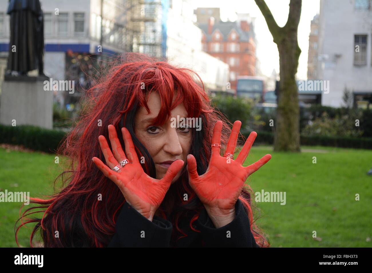 London, UK. 16th Jan, 2016. Protester holds up paint stained hands as a statment about the Japanese government having blood on their hands for their support of the Taiji Dolphin hunt. Credit:  Marc Ward/ Alamy Live News Stock Photo