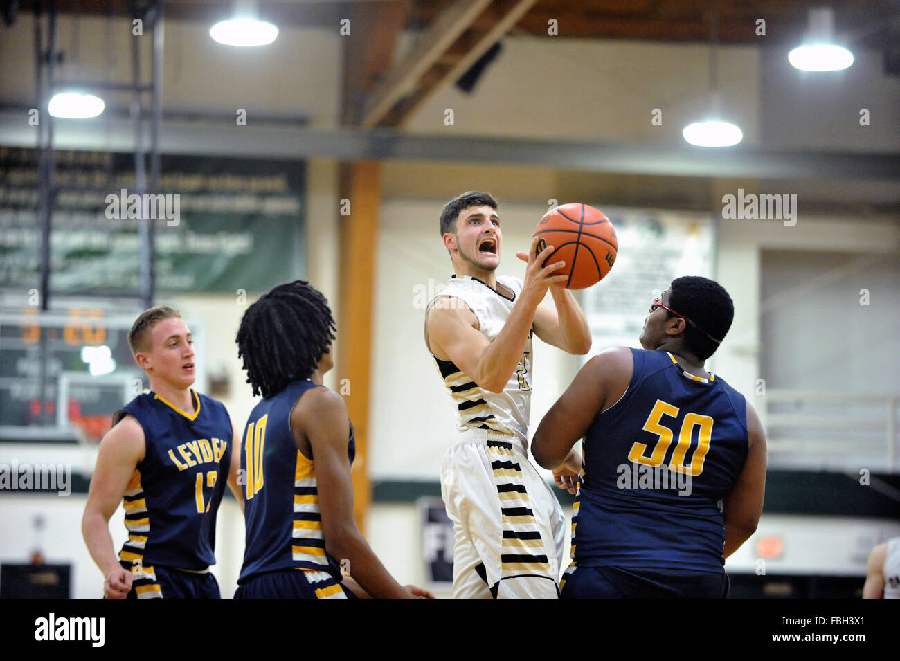 High school forward rising from the floor to get an open look at the basket prior to shooting among a trio of defenders. USA. Stock Photo