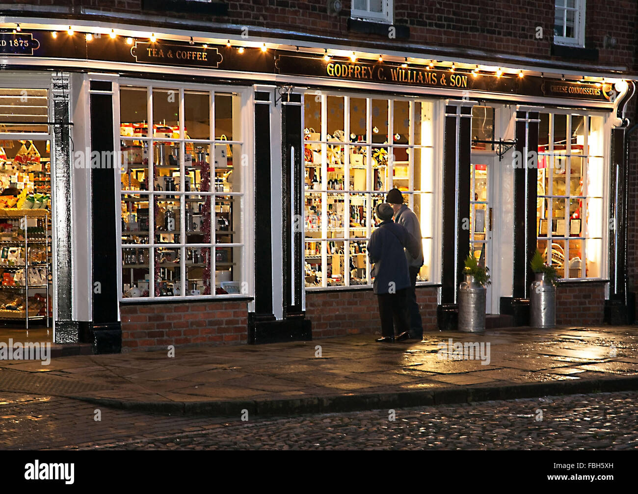 Retired couple looking in a shop window at Christmas time Stock Photo