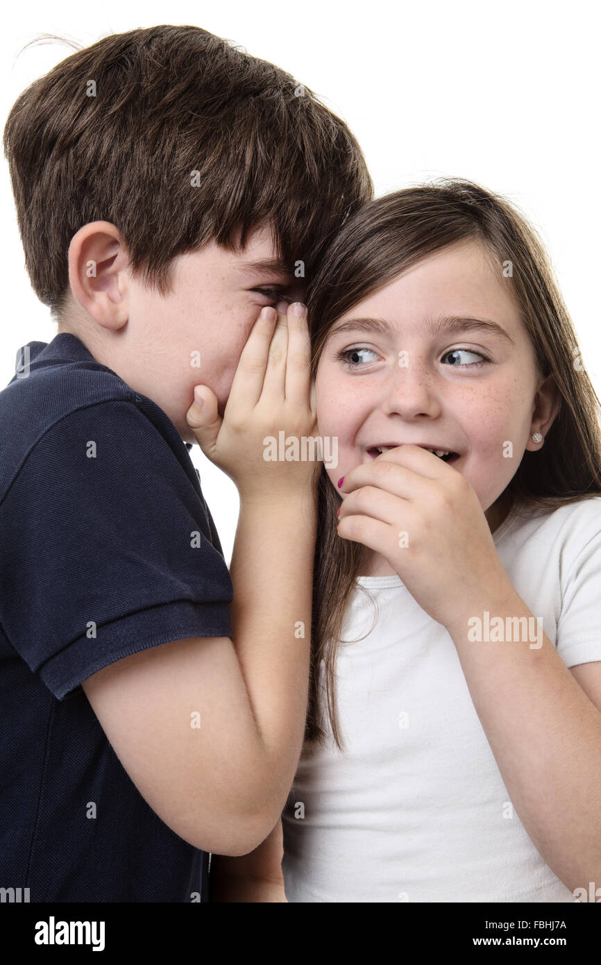 two children whispering into each others ear sharing a secret! Stock Photo