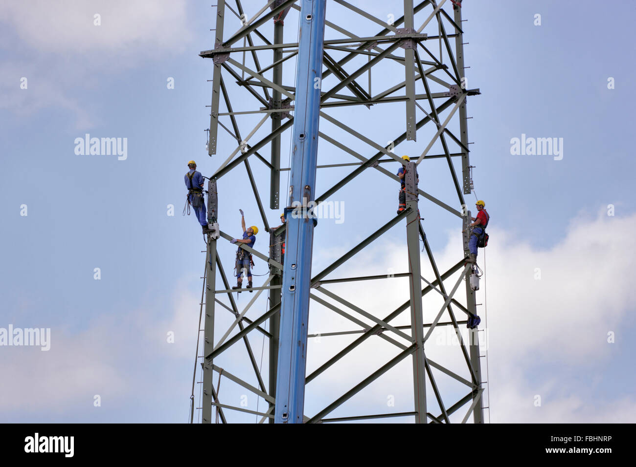 Men mounting high-voltage power pylon, Thuringian Forest Stock Photo
