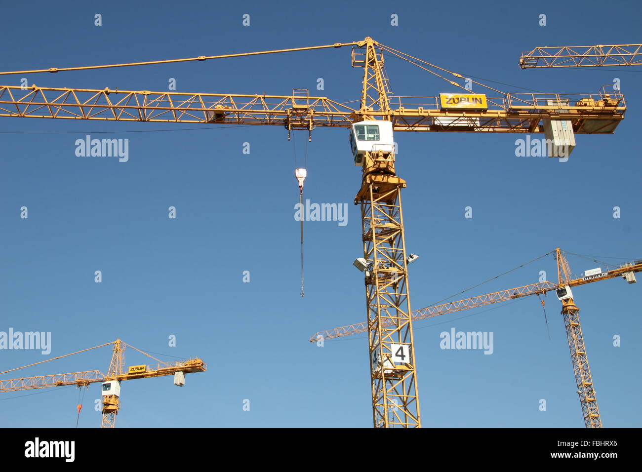 four cranes with blue sky at a building-site Stock Photo