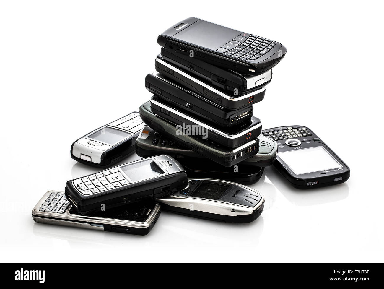 Pile of Old Mobile Phones ready for recycling on a white background Stock Photo
