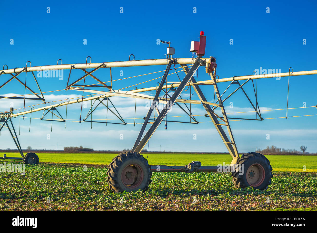 Automated farming irrigation sprinklers on cultivated field Stock Photo