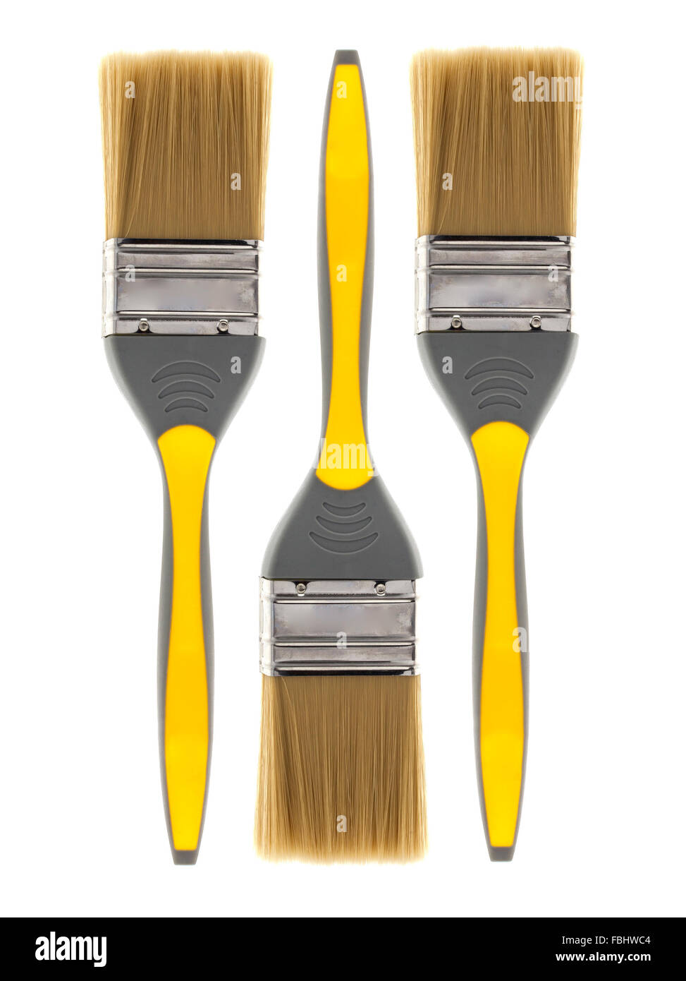Three Yellow Paint brushes on a white background Stock Photo
