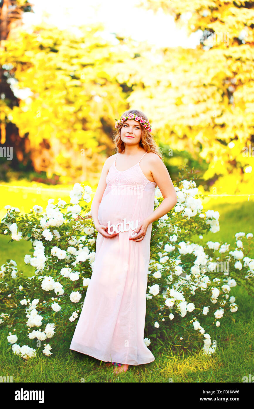Pregnant with a label “Baby” on nature in the park Stock Photo - Alamy