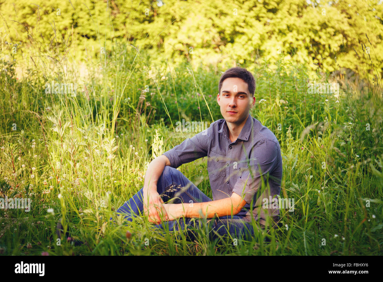 Portrait of a young man on nature in the grass Stock Photo - Alamy