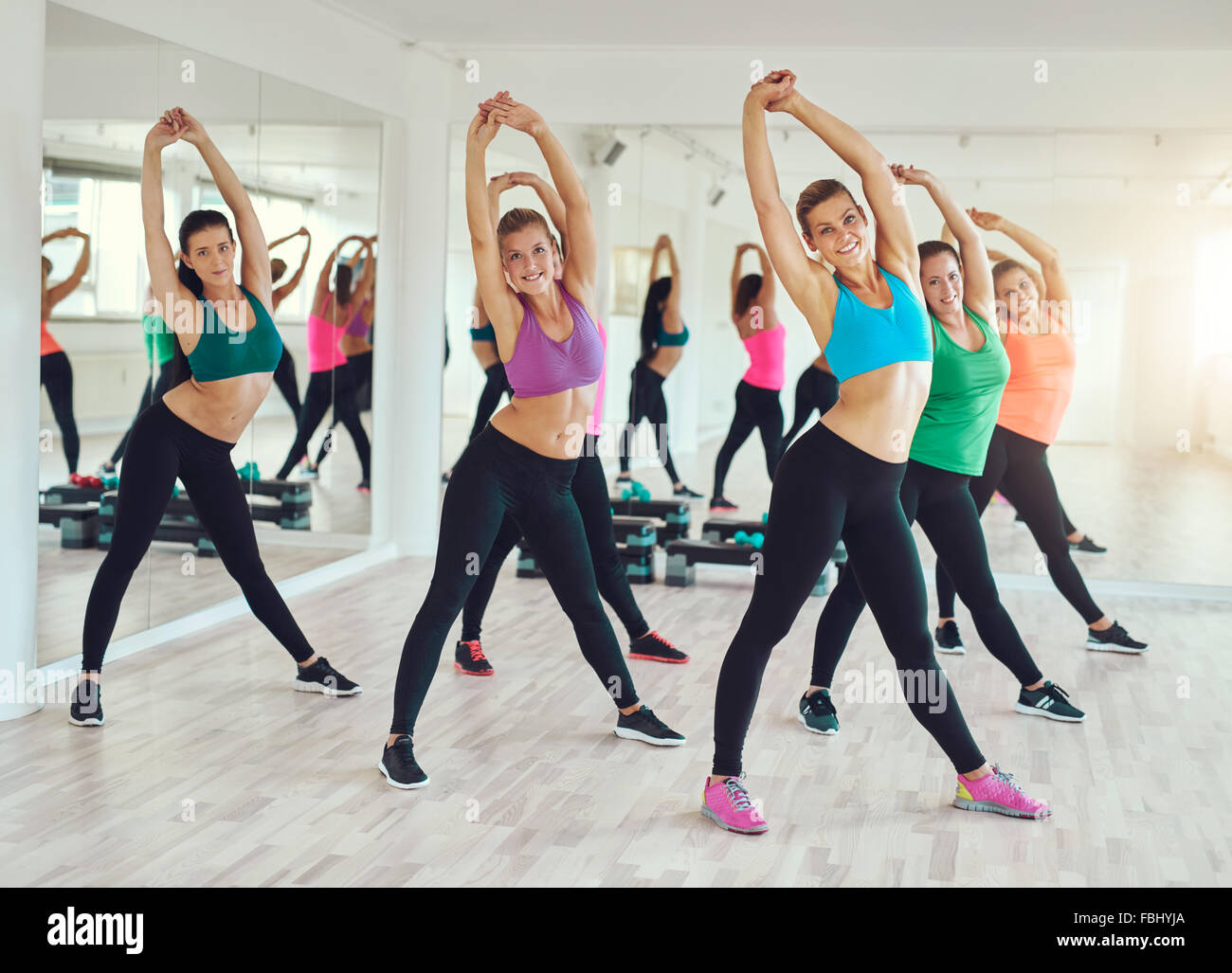 Teamwork of group of women doing exercise and looking at camera. Stock Photo