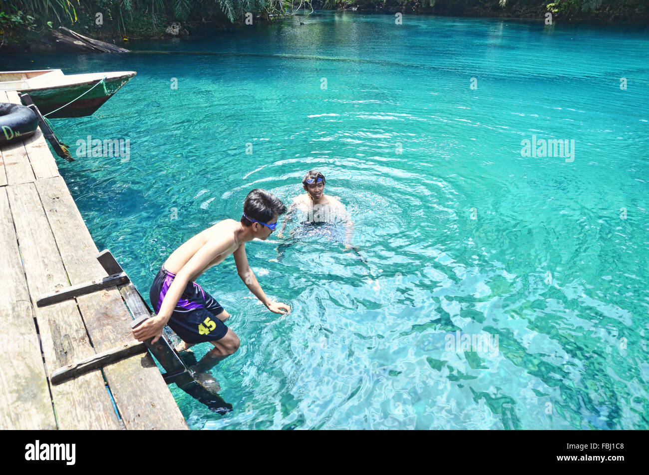 Two boys swimming in Labuan Cermin Lake Stock Photo