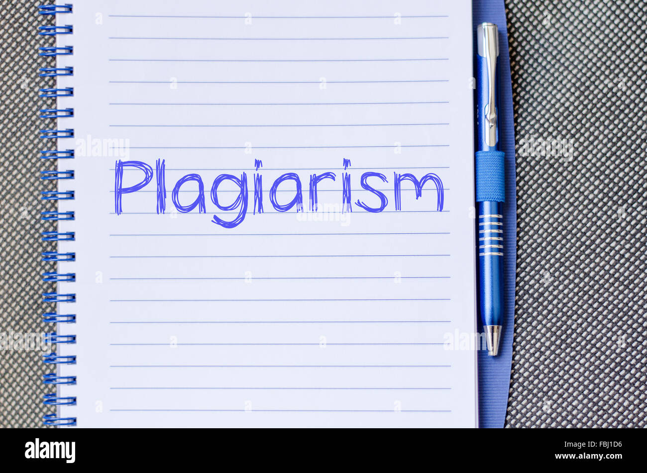 Plagiarism text concept write on notebook with pen Stock Photo