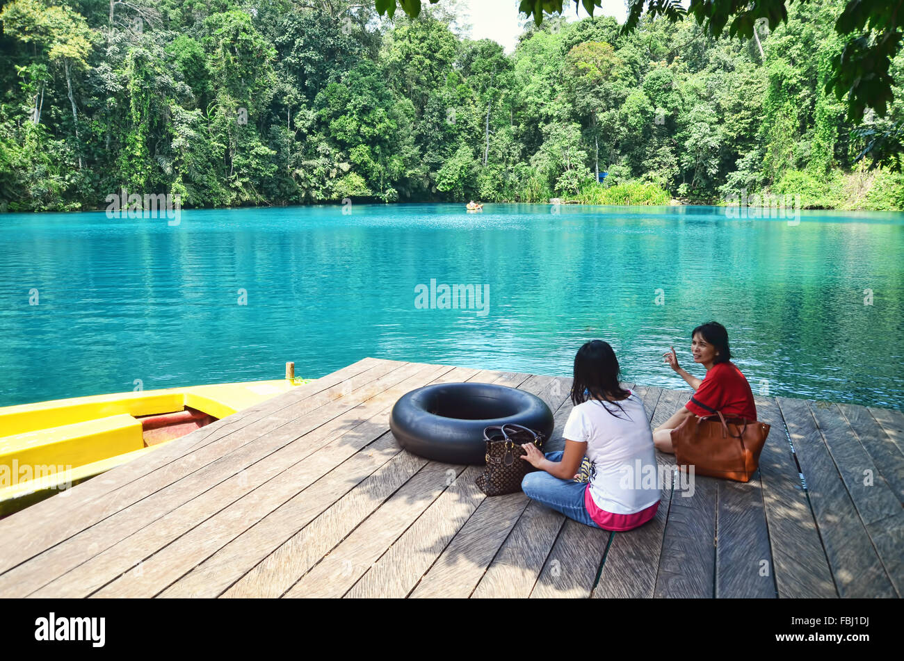 Two women relaxing and chatting by Labuan Cermin Lake Stock Photo