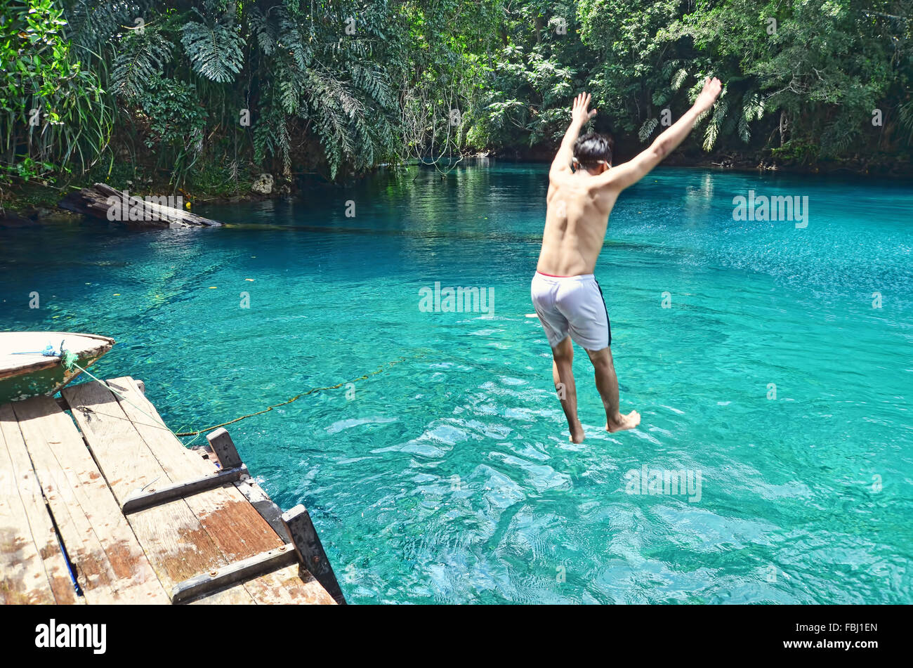 A boy jumping into Labuan Cermin Lake Stock Photo