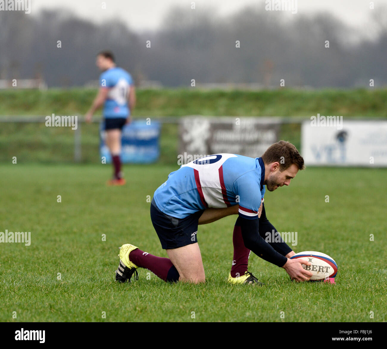 The Wilmslow fly-half paces the ball carefully before attempting a conversion in a rugby match against Broughton Park Stock Photo