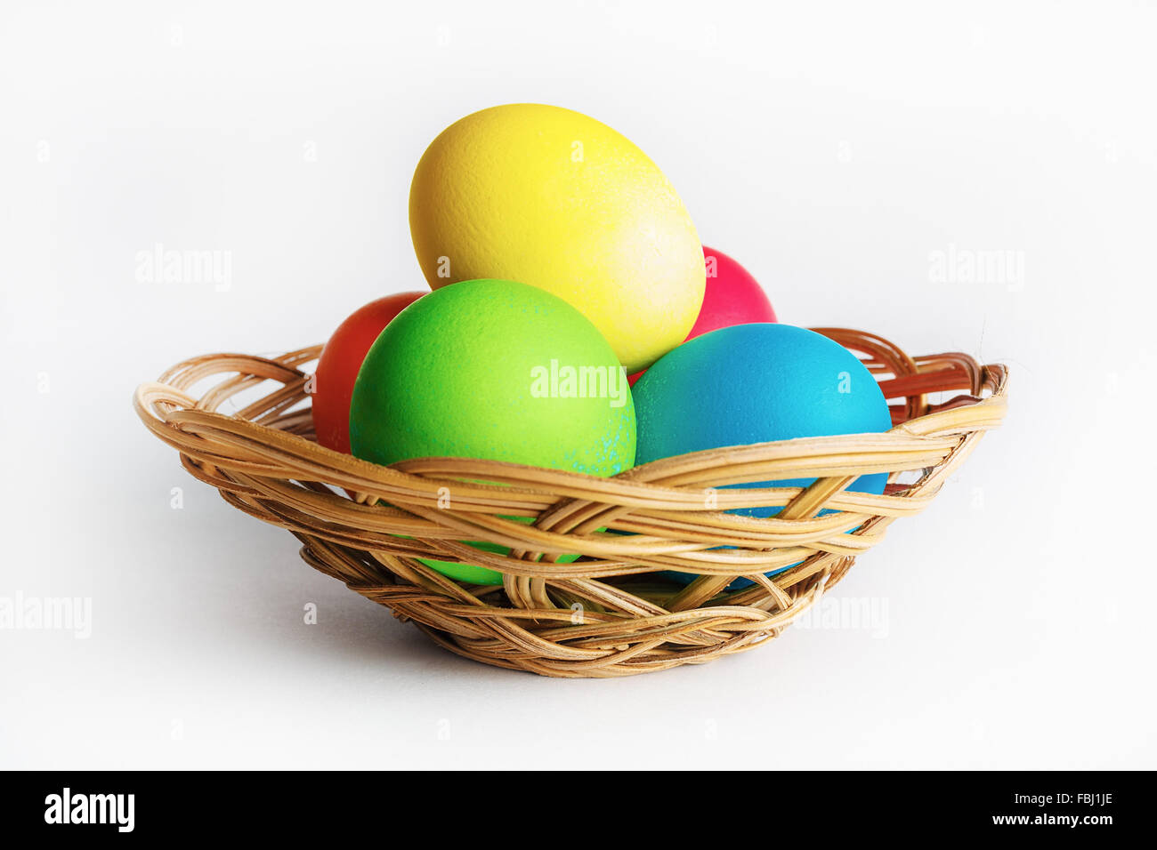 Colorful easter eggs in a wicker basket Stock Photo - Alamy