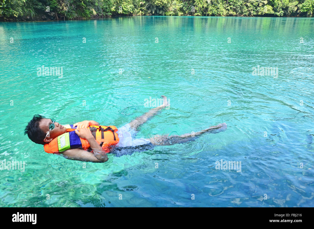 A boy floating in Labuan Cermin Lake Stock Photo