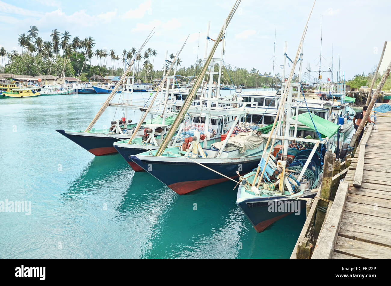 A group of wooden boats are moored by the dock Stock Photo