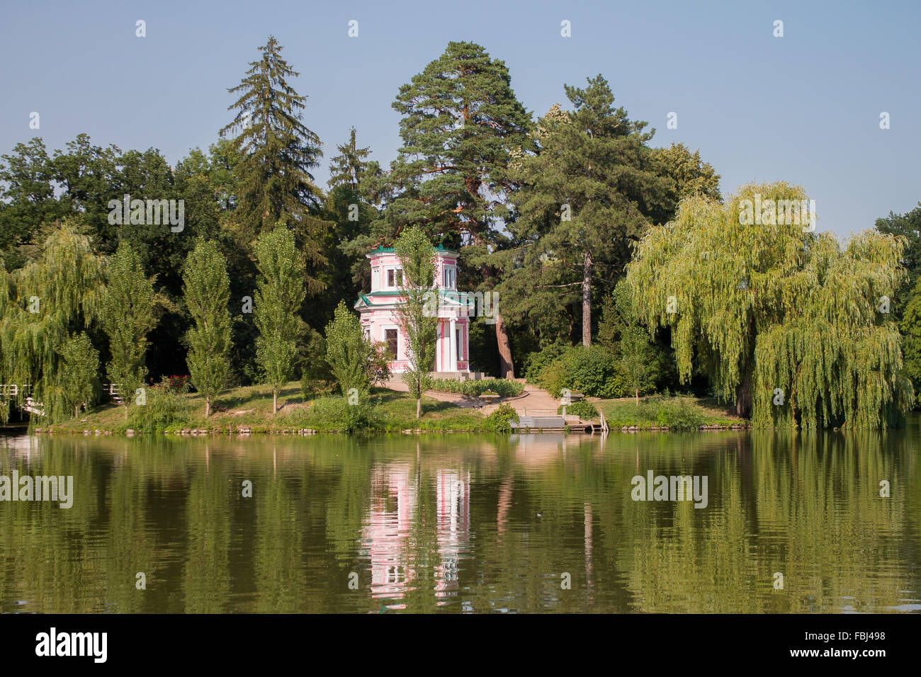 The pink building on a hill near the lake. Summer. Stock Photo
