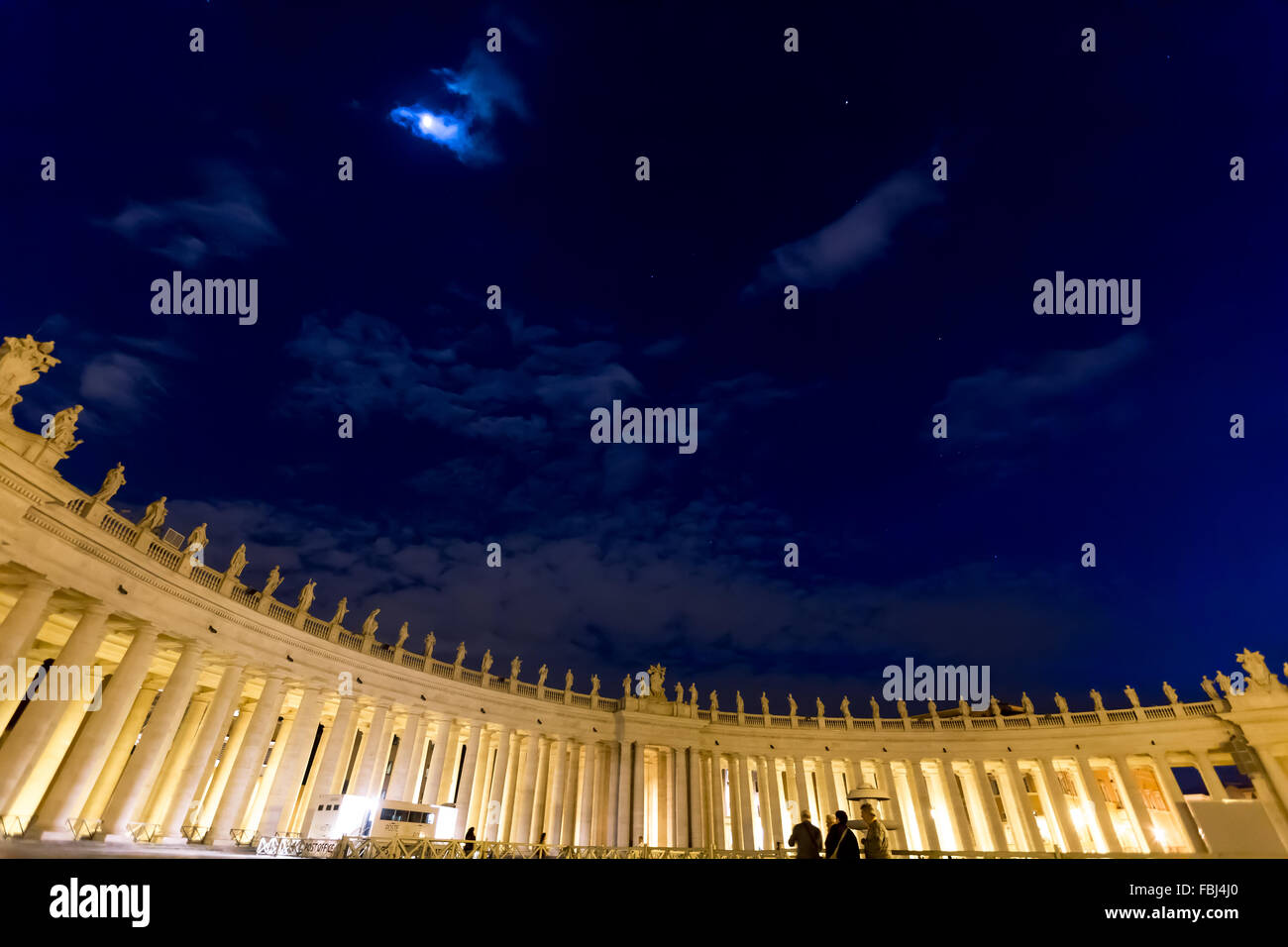 Tourism and sightseeing, night view of Illuminated colonnades on St. Peter's Square in Roma. Moonlit sky. Stock Photo