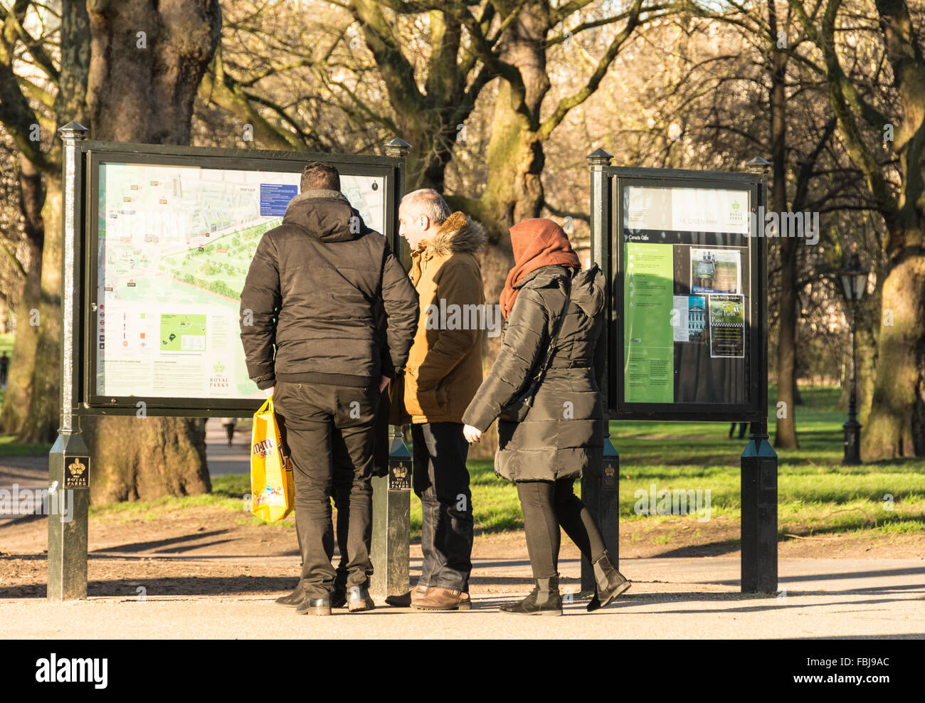 A group of tourists in London looking at a noticeboard in St. Jame's Park Stock Photo