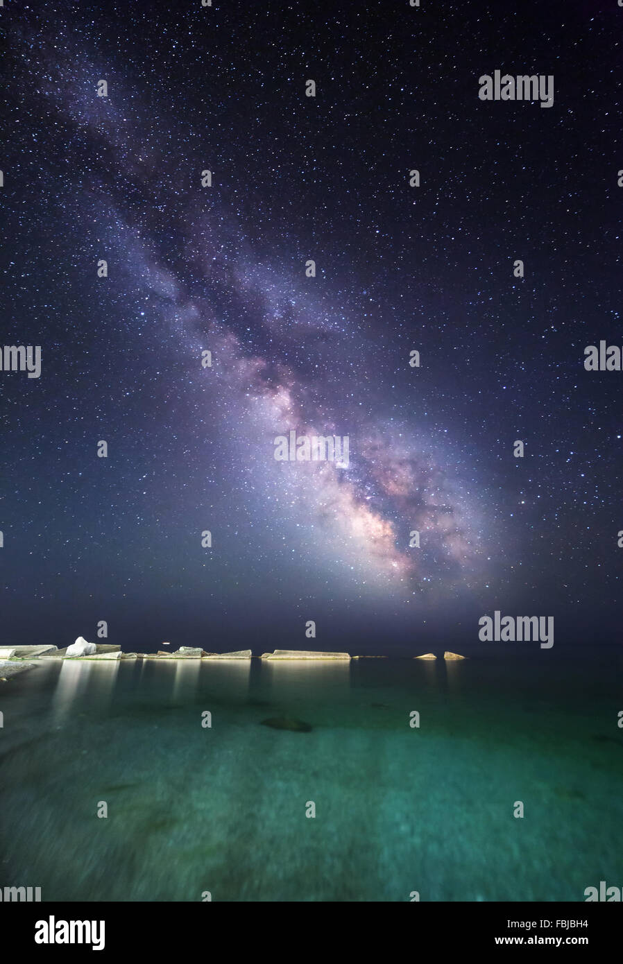 Night landscape with milky way at the sea coast with stones. Starry sky Stock Photo