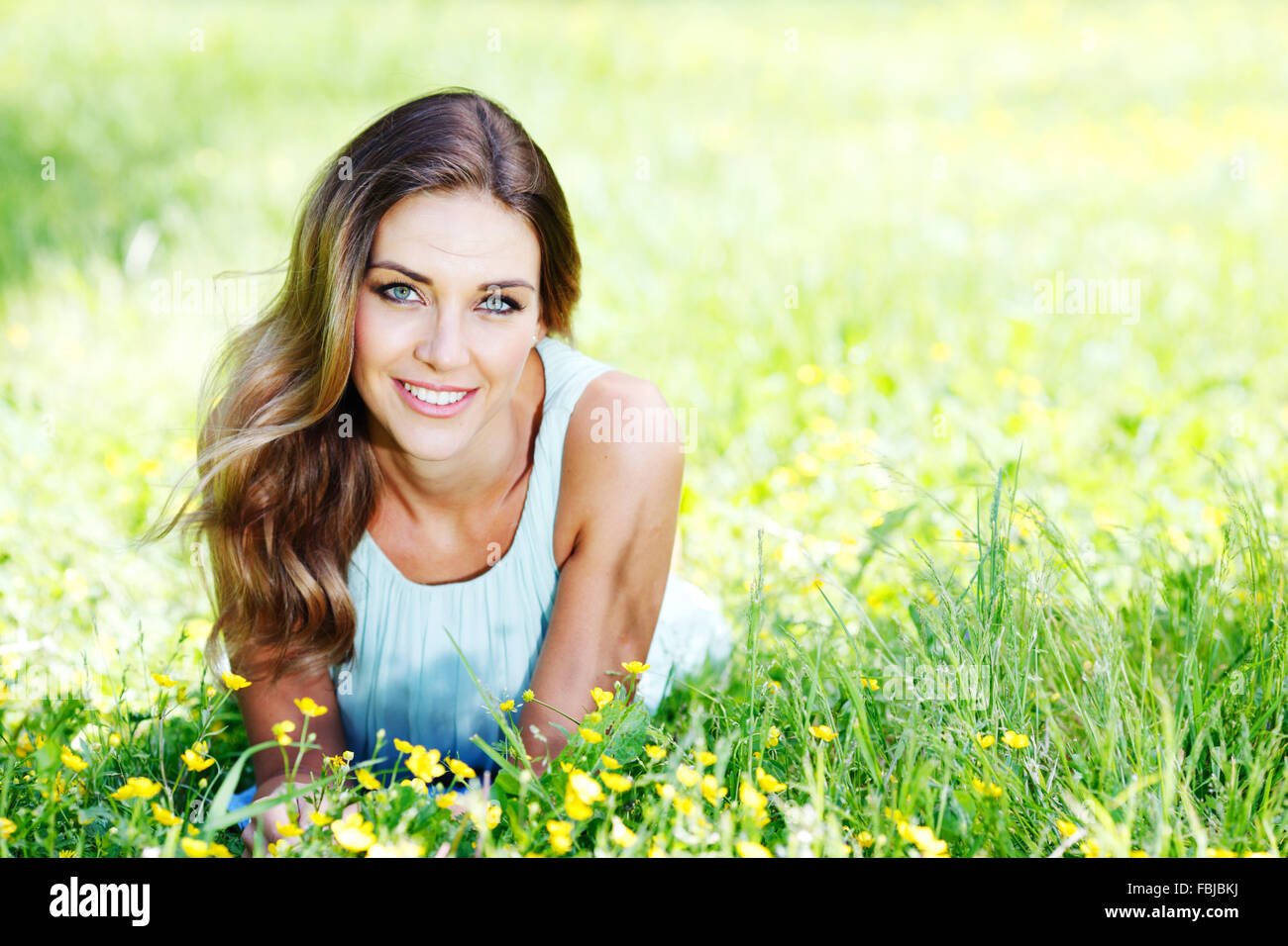 beautiful young woman in blue dress lying on grass Stock Photo - Alamy