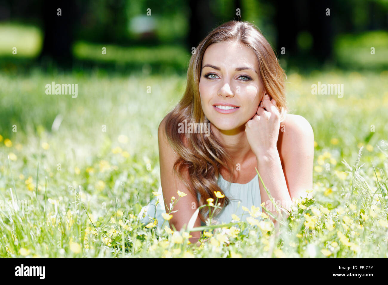 beautiful young woman in blue dress lying on grass Stock Photo - Alamy