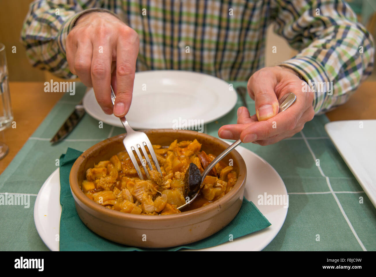 Man's hands serving Callos a la Madrileña in a restaurant, close view. Madrid, Spain. Stock Photo