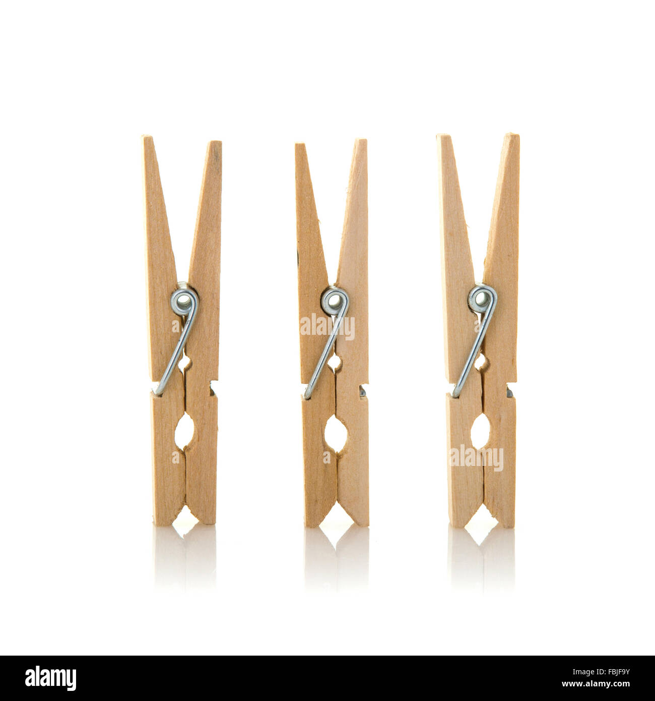 Three wooden cloth pegs on a white background Stock Photo