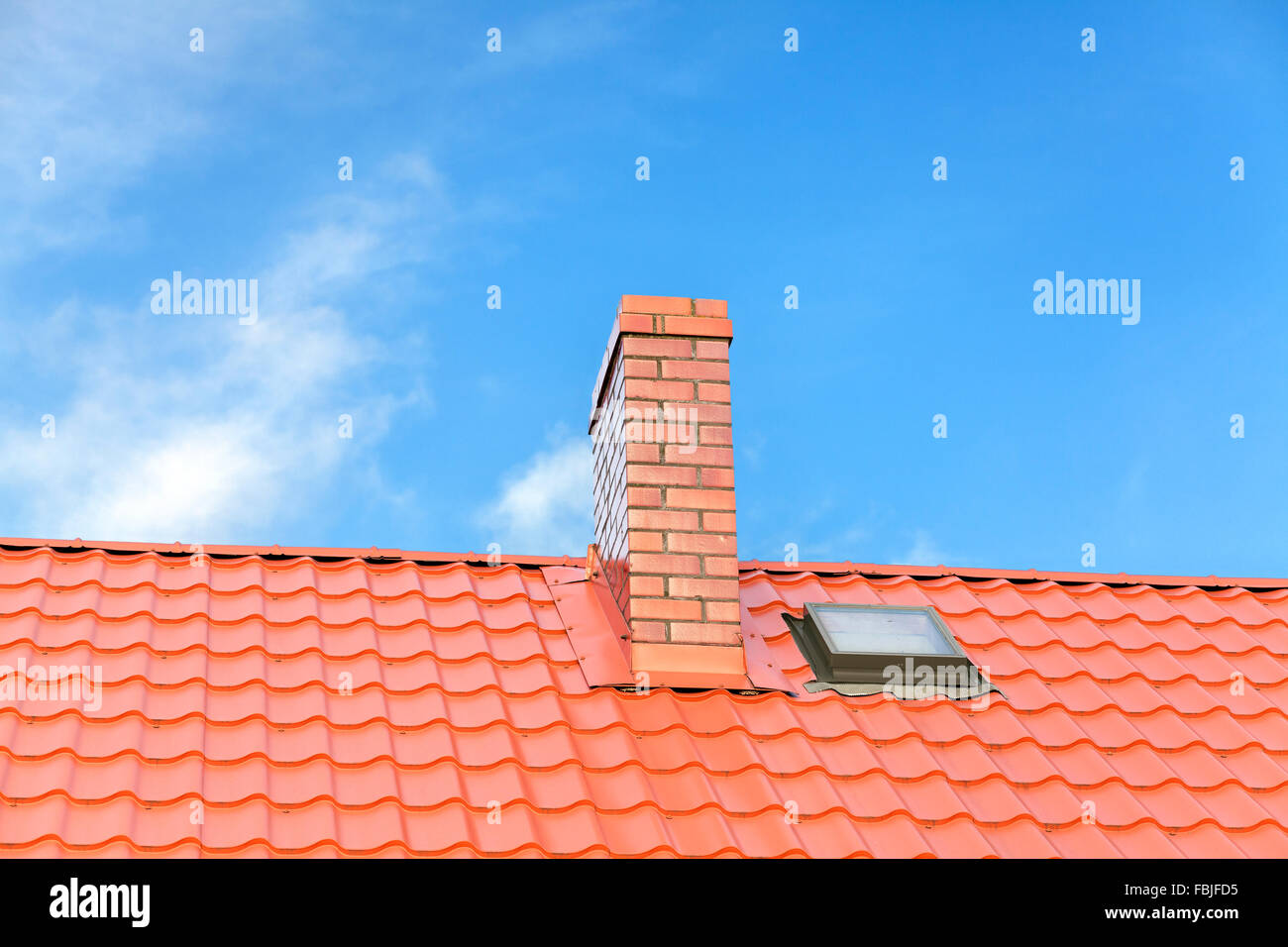 Roof with ceramic tile chimney against blue sky, space for text. Stock Photo