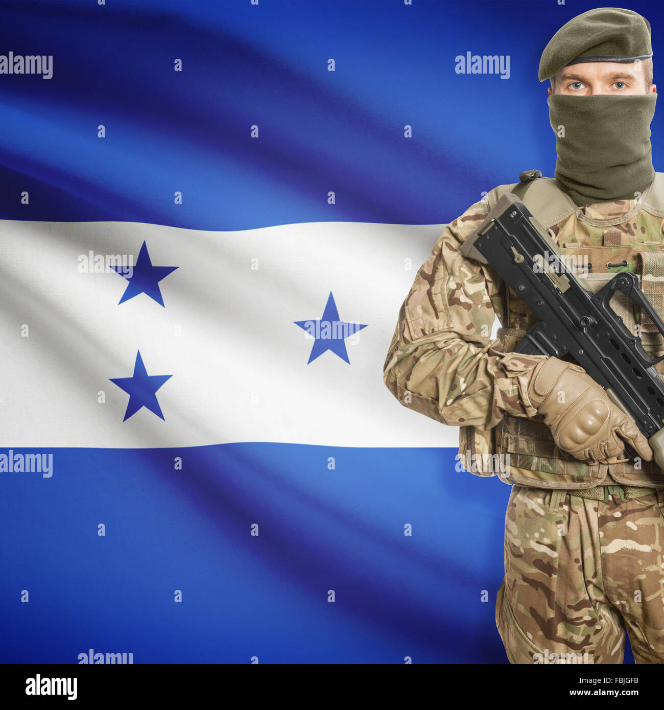 Soldier with machine gun and national flag on background series - Honduras Stock Photo