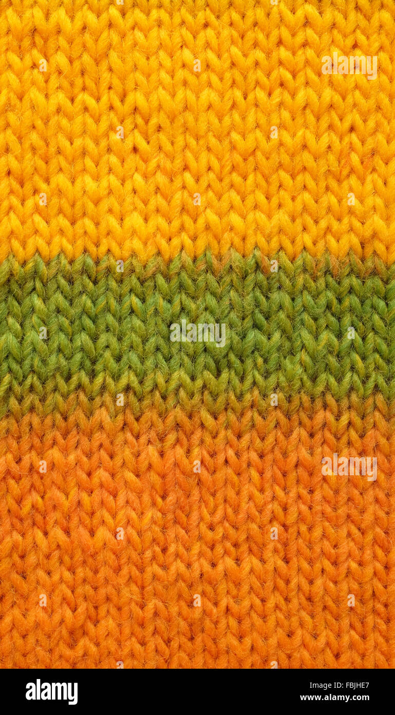 Stocking stitch knitting in yellow, green and orange mixed yarn as an abstract background texture Stock Photo