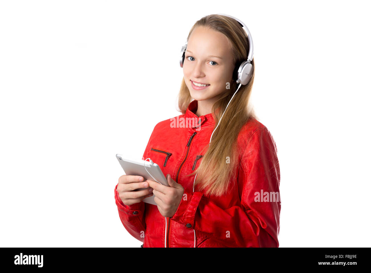 Portrait of happy beautiful casual teenage girl wearing red leather jacket and earphones holding modern tablet, friendly smiling Stock Photo